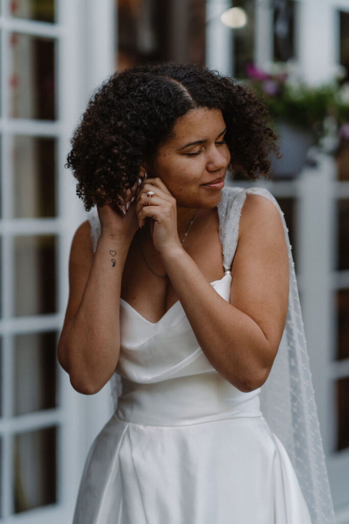 bride putting on her earring before her elopement 