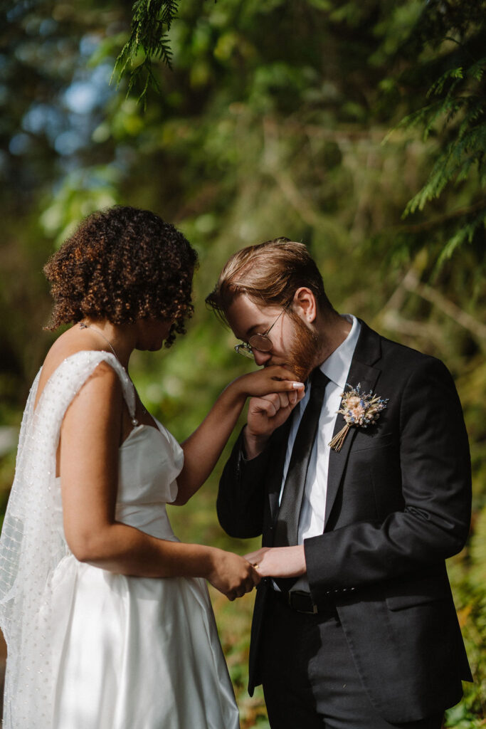 groom kissing his bride hand after the ceremony