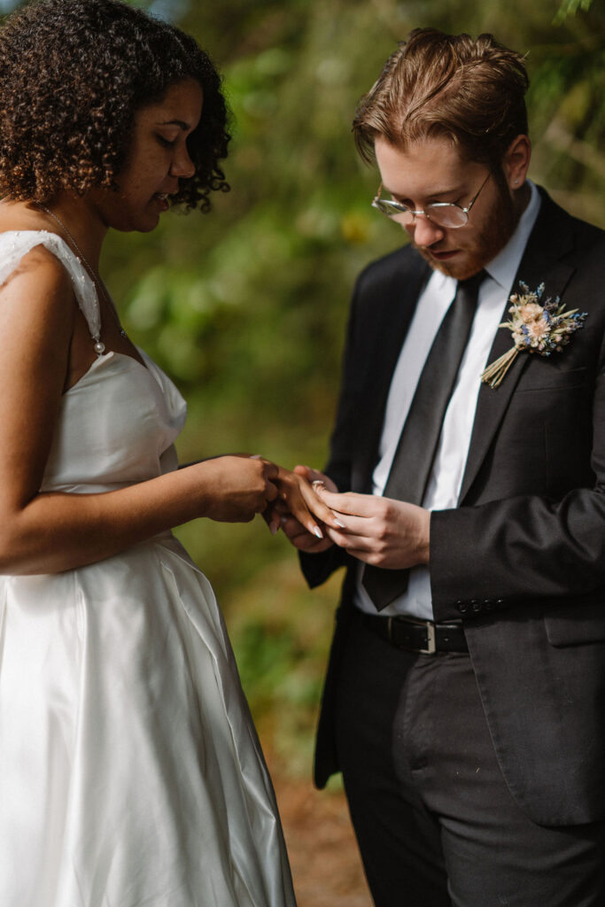 bride and groom putting on their rings 