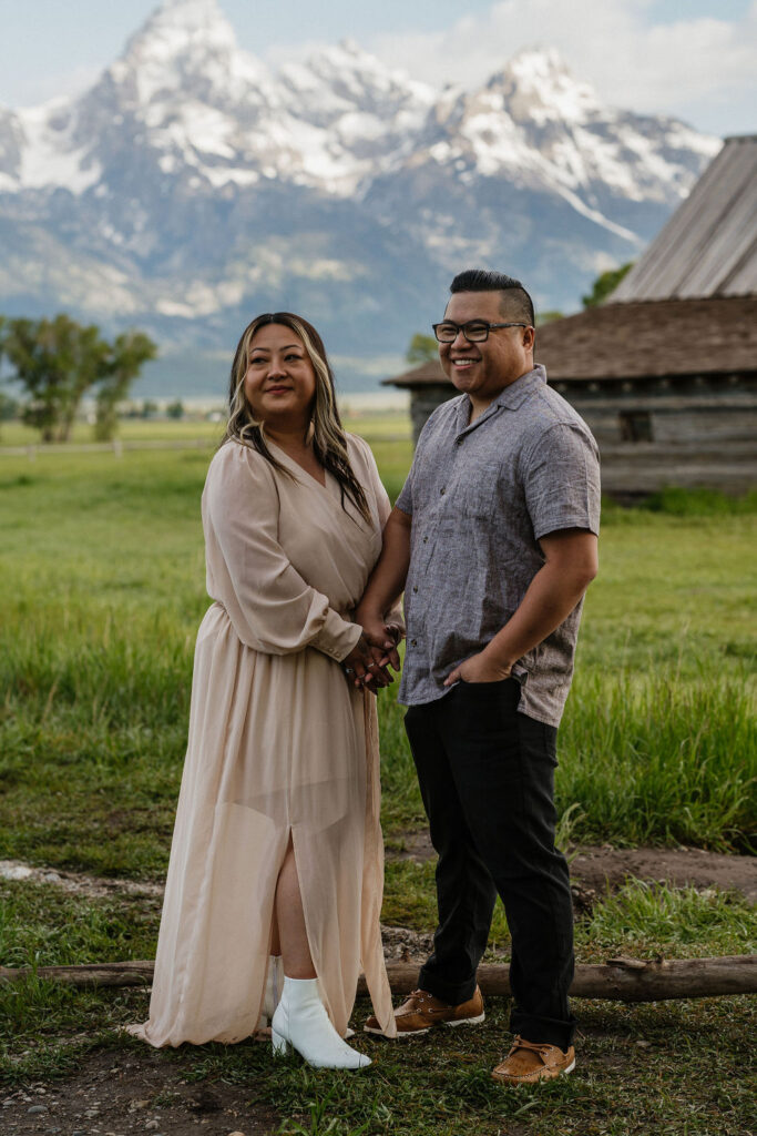 couple holding hands at their romantic boho engagement photoshoot 