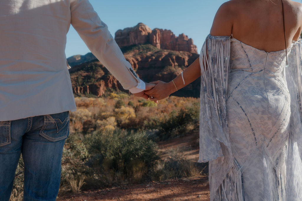 elope in sedona couple holding hands with sedona rocks in the background