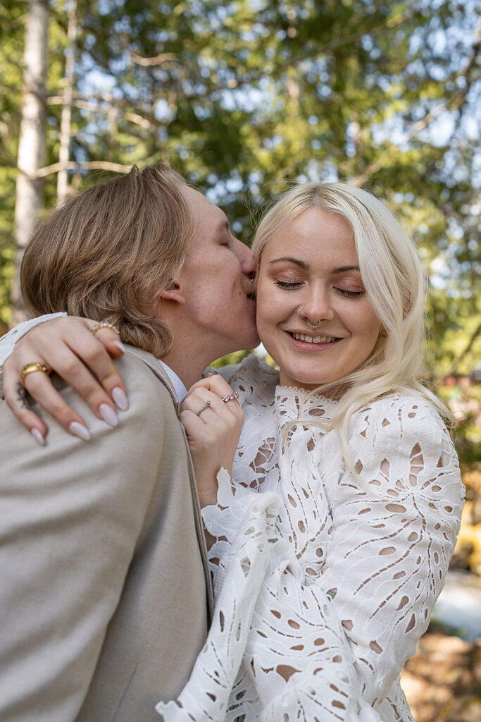 groom kissing the bride on the cheek 