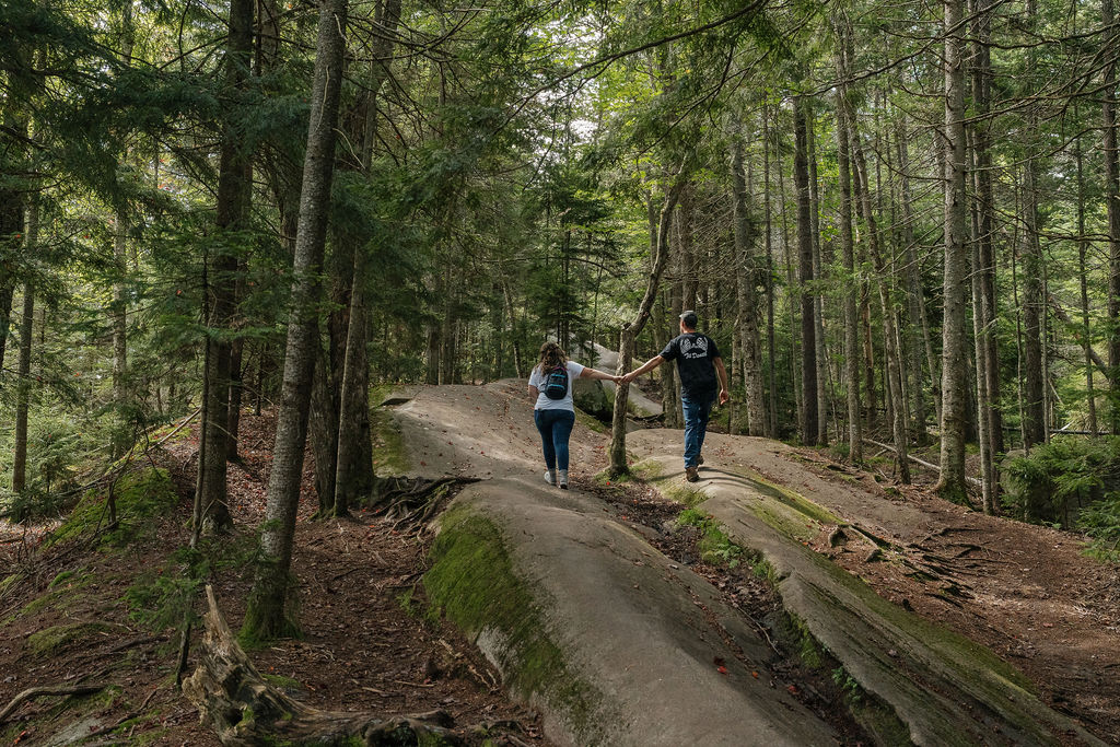 couple holding hands walking around bald mountain 