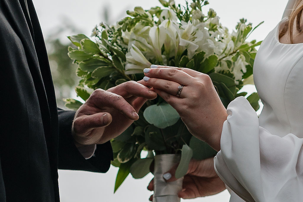 bride and groom putting on their wedding rings