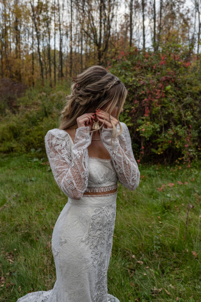 bride putting on her earrings before her elopement ceremony 