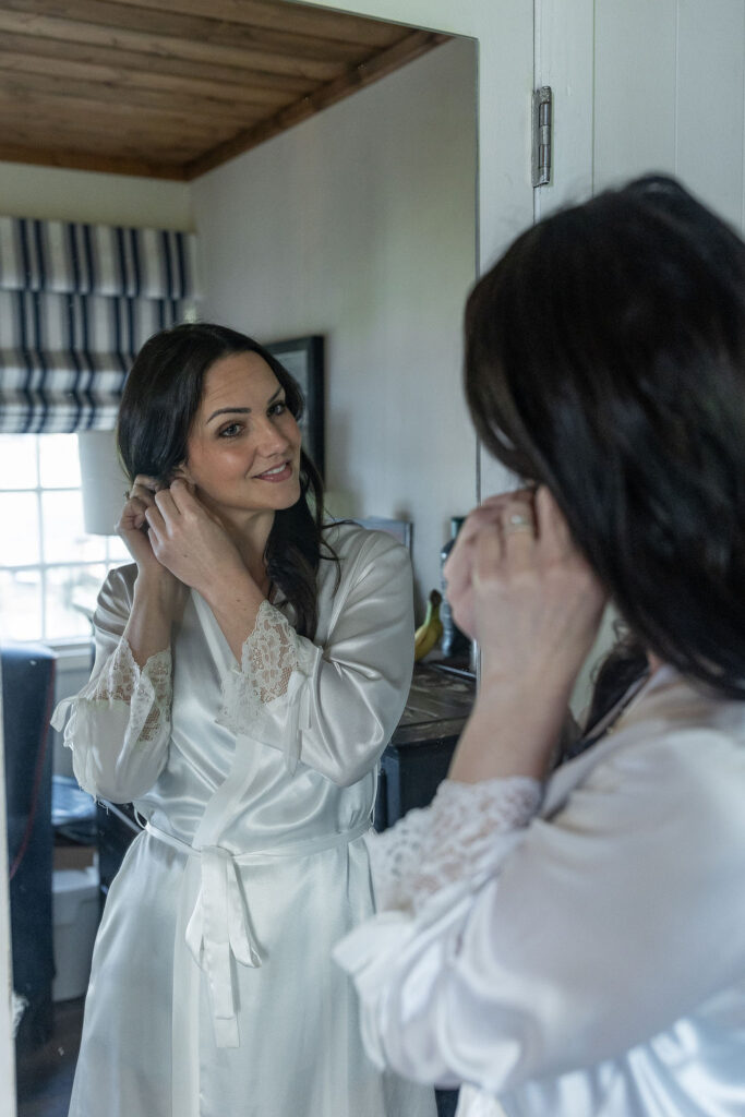 wife putting her jewelry on for her ceremony 