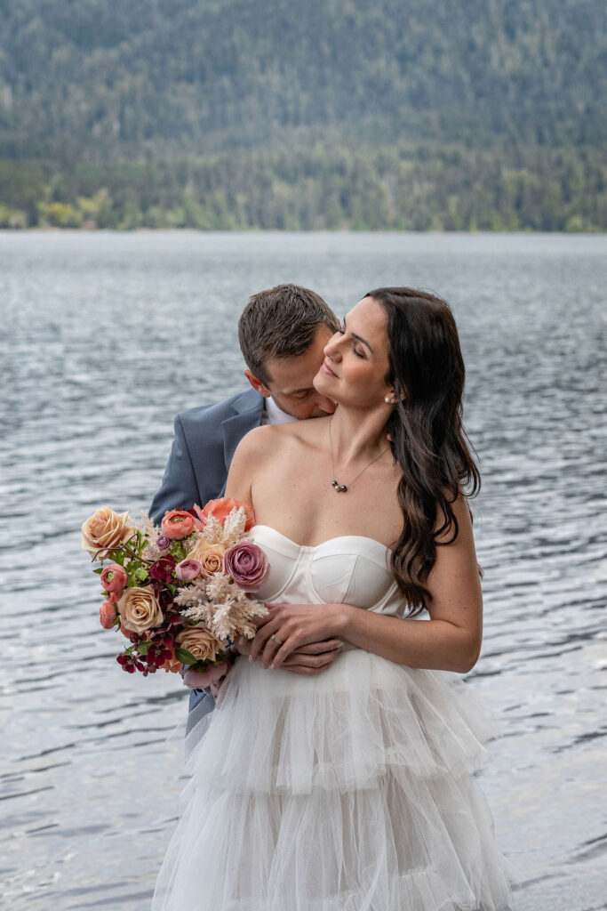 husband kissing his wife on the neck after their romantic vow renewal