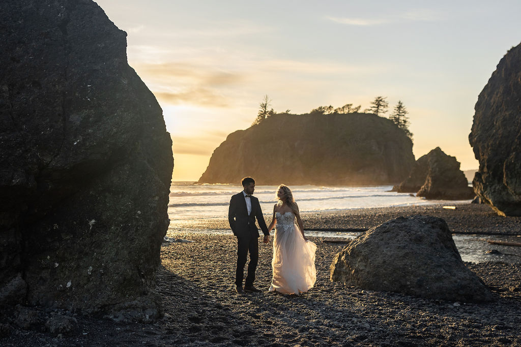 couple holding hands walking around the beach - eloping at ruby beach