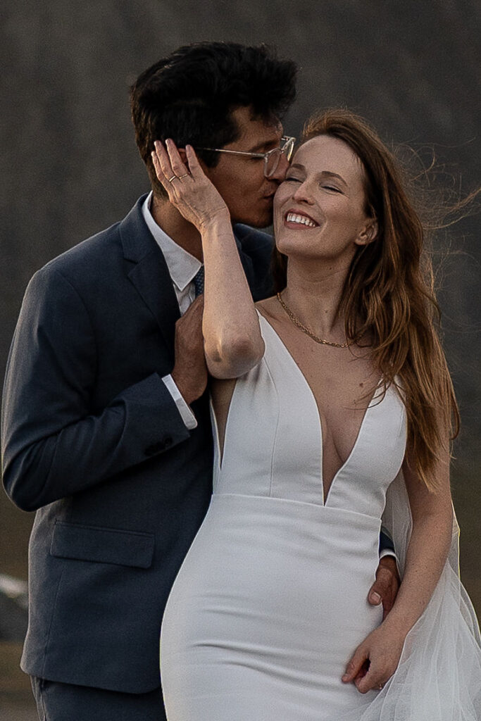 groom kissing the bride on the cheek