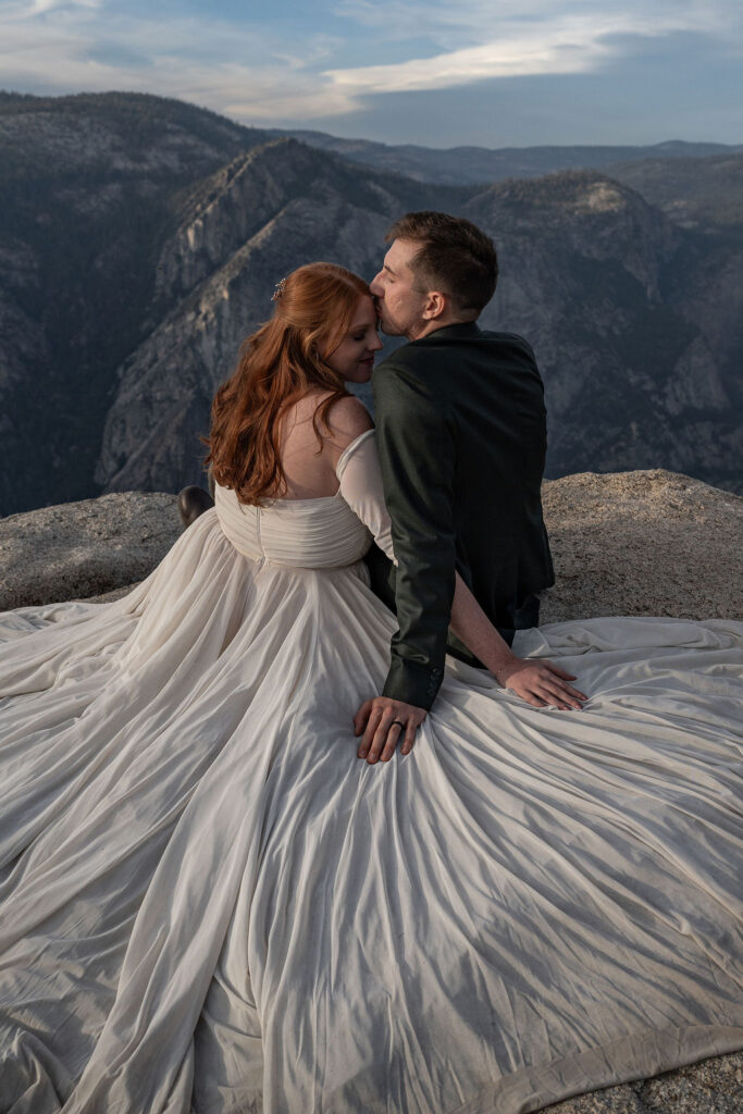 cute picture of the groom kissing the bride on the forehead 