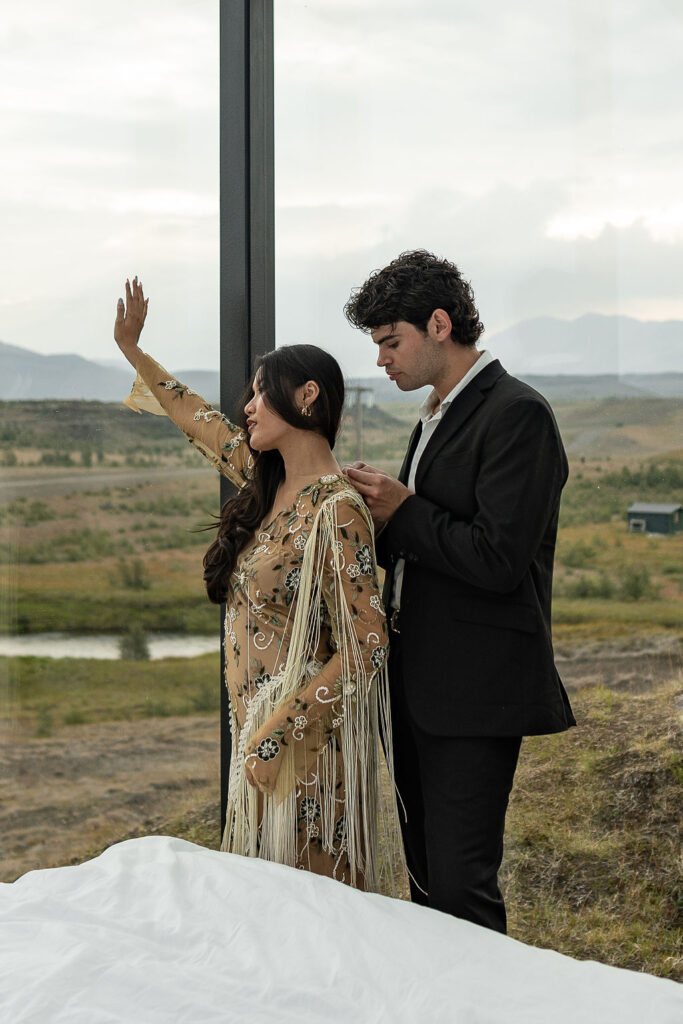 groom helping the bride with her elopement dress